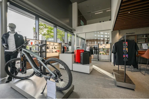 The accessory display in the Porsche showroom with a bicycle, clothing stands and shelves.