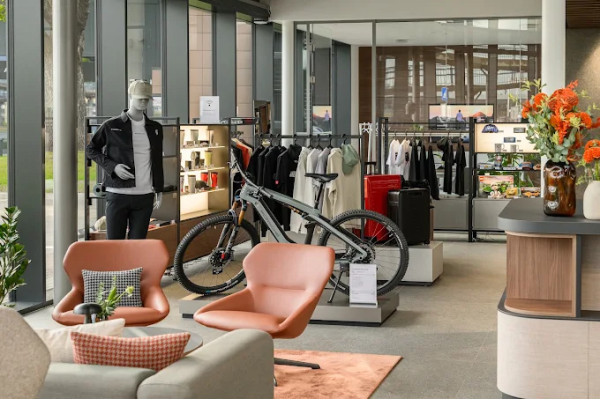 Salon relaxation and accessories area with chairs, bicycle and glazed partitions.