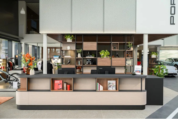 Central piece of furniture with open wooden shelves and low light cabinets in the Porsche showroom.