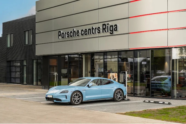 The Porsche Center Riga sign above the entrance and a blue car.