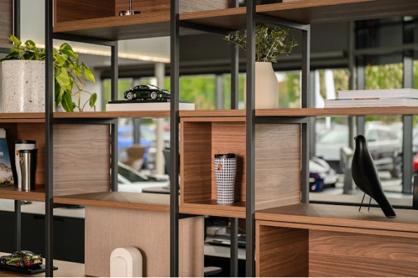 Detail of the open wooden shelving system with a dark metal frame and decorative objects.