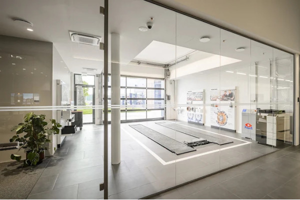 Glass partitions and a bright car display area with a tiled floor.