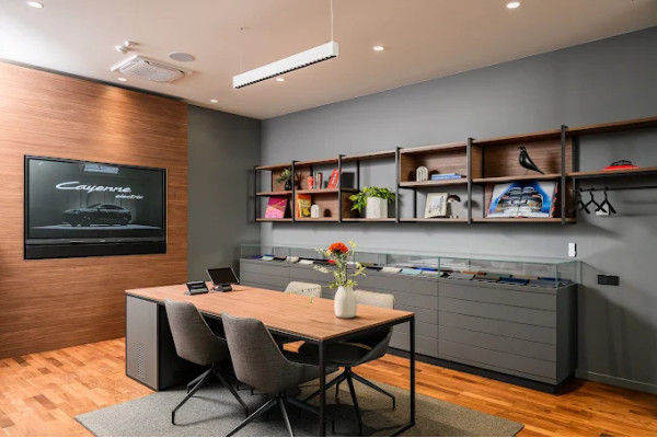 The kitchen and meeting area with gray cabinets, open shelves and a wooden table.